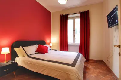 a bedroom with a bed with red walls and a window at Charming Vatican LargeApt by YH in Rome