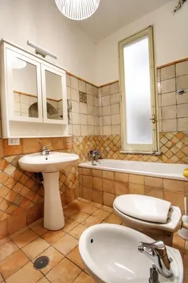 a bathroom with a sink and a toilet and a tub at Charming Vatican LargeApt by YH in Rome