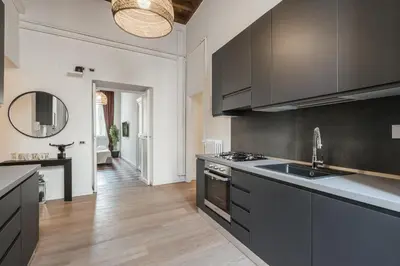 a kitchen with black cabinets and a sink at The best in Rome Monserrato in Rome