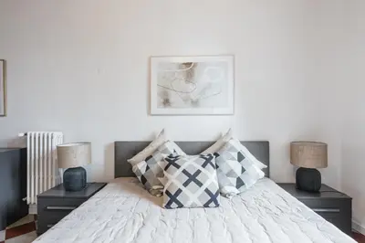 a bedroom with a white bed with two night stands at The best in Rome Monserrato in Rome