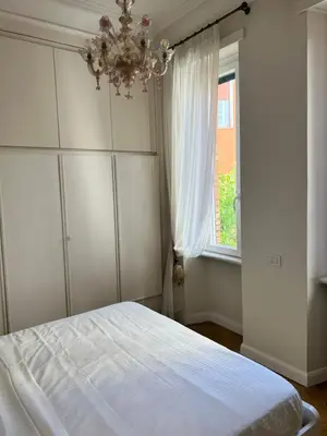 a bedroom with a bed with a chandelier and a window at Circo Massimo Sweet Home - next to FAO in Rome