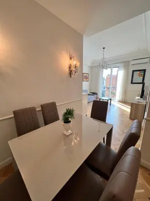 a dining room with a white table and leather chairs at Circo Massimo Sweet Home - next to FAO in Rome