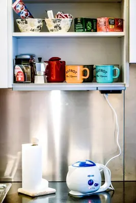 a shelf with cups and a tea pot on a table at Lovely apartment in Rome - Casetta Mattei in Rome