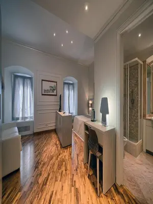 a bedroom with a bed and a desk and a mirror at Polinari Rooms San Pietro Roma in Rome