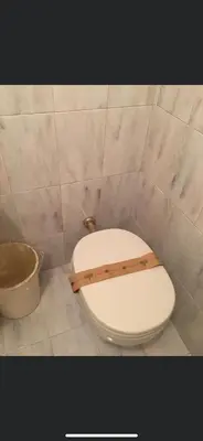 a white toilet in a bathroom with a bucket at La casetta a monti in Rome