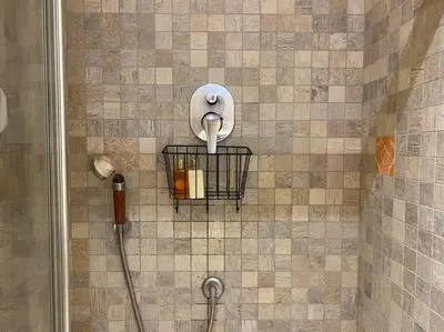 a shower with a shower head on a tiled wall at New! Uptown Terraces in Rome