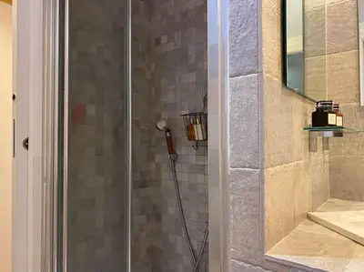 a shower with a glass door in a bathroom at New! Uptown Terraces in Rome