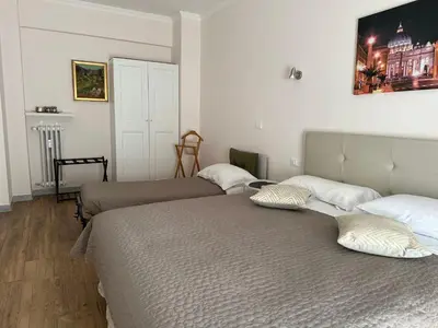 a bedroom with two beds and a picture on the wall at GOLDEN ROOMS Cipro in Rome