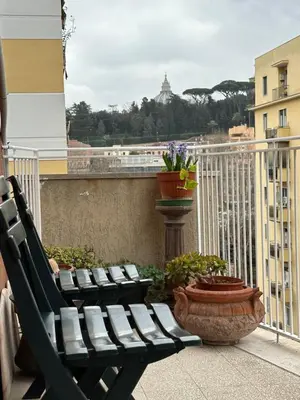 two benches on a balcony with a view of a city at GOLDEN ROOMS Cipro in Rome