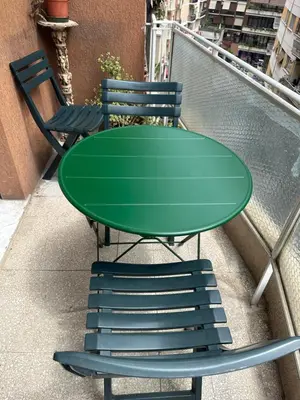 a green table and two chairs on a balcony at GOLDEN ROOMS Cipro in Rome