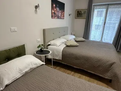 a bedroom with two beds and a table and a window at GOLDEN ROOMS Cipro in Rome