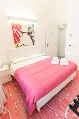a large bed in a room with a pink blanket at Divine Bed & Breakfast in Rome