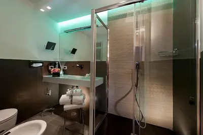 a bathroom with a glass shower and a sink at Argentina Residenza Style Hotel in Rome