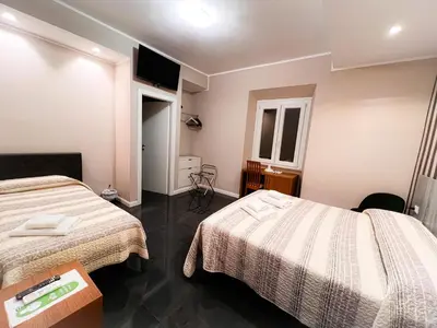 a hotel room with two beds and a table at Hotel Sallustio in Rome