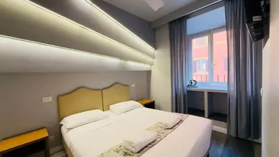a bedroom with a large bed with a window at Hotel Sallustio in Rome