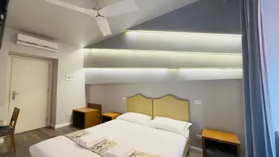 a bedroom with two beds and a large window at Hotel Sallustio in Rome
