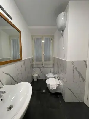 a white bathroom with a sink and a toilet at Hotel Sallustio in Rome