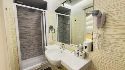 a bathroom with a sink and a shower and a mirror at Hotel Sallustio in Rome