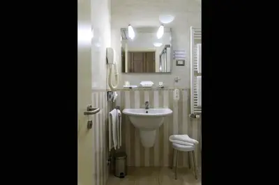 a bathroom with a sink and a toilet and a mirror at Domus Australia in Rome