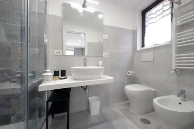 a bathroom with a sink and a toilet and a shower at Roman Holiday Suites in Rome