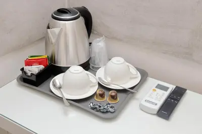 a tray with two dishes and a coffee pot on a counter at Roman Holiday Suites in Rome