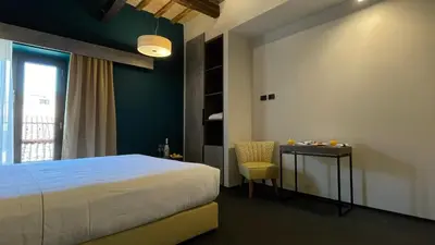 a bedroom with a bed and a table and a chair at Passpartout Boutique Palace in Rome