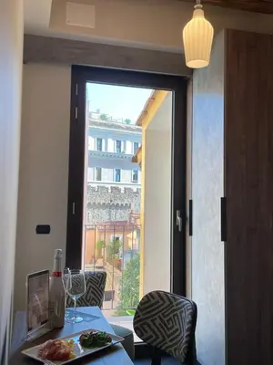 a table with a plate of food and a window at Passpartout Boutique Palace in Rome