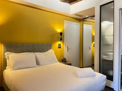 a bedroom with a white bed with a yellow wall at Passpartout Boutique Palace in Rome