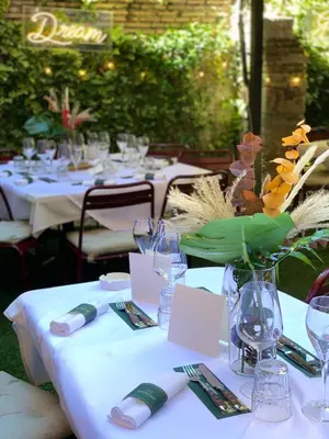 a table with plates and glasses and a vase with flowers at Passpartout Boutique Palace in Rome