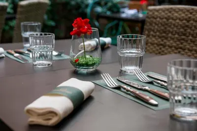 a table with a red flower in a vase on it at Passpartout Boutique Palace in Rome
