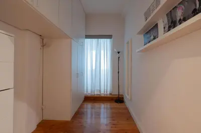 a hallway with white walls and wooden floors and a window at Domus Montebello in Rome