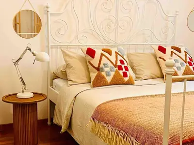 a bedroom with a bed with a lamp and pillows at d-cube camera Colosseo in Rome