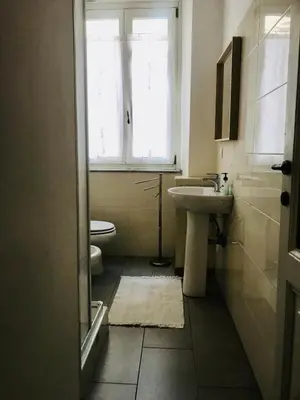 a bathroom with a sink and a toilet and a window at d-cube camera Colosseo in Rome