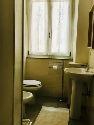 a bathroom with a toilet and a sink and a window at d-cube camera Colosseo in Rome