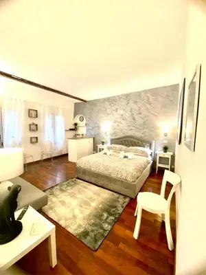 a bedroom with a bed and a table and a chair at NAVONA SUITE VIOLA in Rome