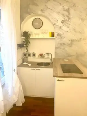 a kitchen with a sink and a clock on the wall at NAVONA SUITE VIOLA in Rome