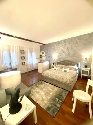 a bedroom with a bed and a table and a chair at NAVONA SUITE VIOLA in Rome
