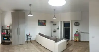 a living room with a white couch and a clock at casa di lella ai musei vaticani in Rome