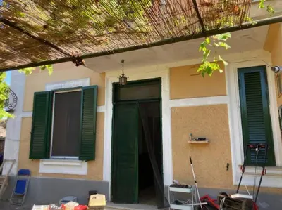 a house with a green door and green shutters at Green house di Alberto in Rome