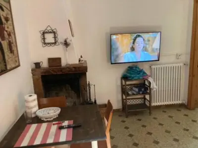 a living room with a table and a tv on the wall at Green house di Alberto in Rome