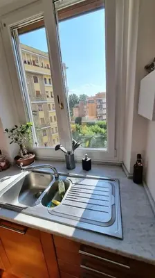 a kitchen with a sink and a large window at Quarto Piano - intero alloggio a Roma in Rome