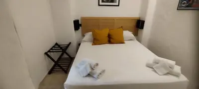 a bedroom with a white bed with yellow pillows at Casa Bertani in Rome