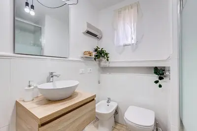 a white bathroom with a sink and a toilet at Pigna suite in Rome