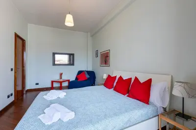 a bedroom with a large bed with red pillows at 2 Vatican St Peter's Daniele apartment Barone in Rome