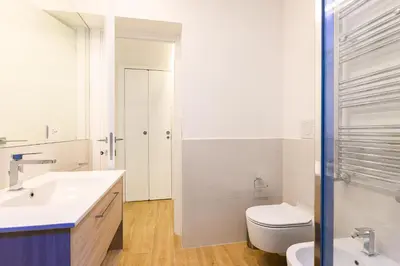 a white bathroom with a toilet and a sink at Modern & Elegant by NDP rent in Rome