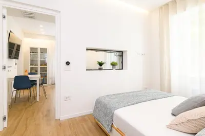 a white bedroom with a bed and a table at Modern & Elegant by NDP rent in Rome