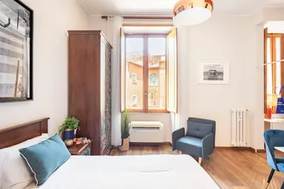 a bedroom with a bed and a chair and a window at 4 Townhouse by the Spanish Steps in Rome