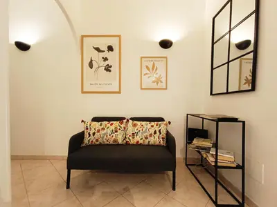 a living room with a chair and a table at LAVINIA VATICAN HOME in Rome