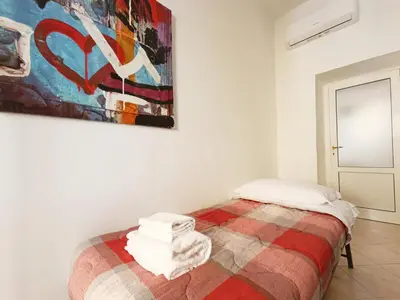 a bedroom with a bed and a painting on the wall at LAVINIA VATICAN HOME in Rome