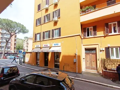 a black car parked in front of a yellow building at LAVINIA VATICAN HOME in Rome